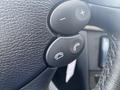 Close-up of the steering wheel buttons in a 2007 Mercedes-Benz E-Class featuring volume control and telephone functions