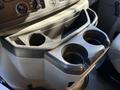 A close-up view of the cup holders in a 2021 Ford E-450 with two circular openings for beverages and a storage compartment above them