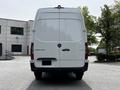 A 2023 Mercedes-Benz Sprinter van viewed from the rear with a sleek white exterior and the model name "SPRINTER" displayed on the back