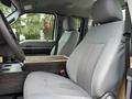 A 2015 Ford F-350 SD driver's seat with a cloth interior and a wooden console between the seats