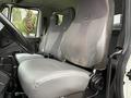 A 2012 International TerraStar's interior cab showcasing two gray upholstered front seats with a console between them