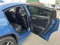 Interior view of a blue 2022 Dodge Charger showing the open rear door with black upholstery and seating visible inside