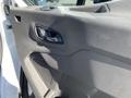 The interior door panel of a 2022 Ford Transit featuring the door handle and speaker grille