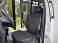 A black driver's seat inside a 2020 Chevrolet Express van with a steering wheel and dashboard visible