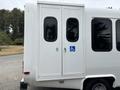 A white 2014 Ford E-350 van with double doors at the back featuring a wheelchair accessibility symbol
