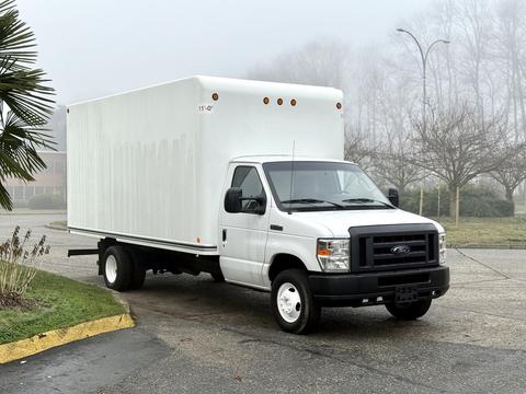 A 2019 Ford Econoline box truck in white with a large enclosed cargo area and black grille parked on a pavement