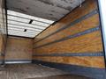 Interior of a 2022 Ford F-750 truck with a wooden floor and side walls featuring metal tracks for securing cargo