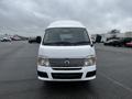 A 2002 Nissan Van in white with a silver grille viewed from the front with large headlights and side mirrors visible