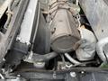 Close-up of the engine components of a 2014 John Deere 1585 Terrain Cut including a metal cover wires and pipes