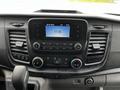 The dashboard of a 2020 Ford Transit featuring a touchscreen display with clock and media controls including knobs for climate control