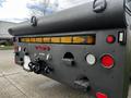 The rear view of a 2008 International 7500 truck featuring red and amber lights a tow hook and various other fittings and connectors