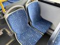 Two blue patterned bus seats with light-colored frames are arranged side by side in a public transport vehicle