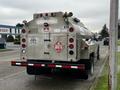 A silver 2018 Ford F-550 fuel delivery truck with a cylindrical tank marked flammable and a red diamond safety sign on the rear