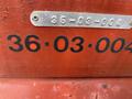 A close-up of a red surface featuring a metal plate with the numbers 36-03-004 prominently displayed in black text