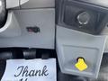 Dashboard controls of a 2015 Ford F-750 featuring a switch and a yellow button above a crumpled napkin with the word Thank written on it
