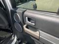 Interior door panel of a 2006 Land Rover LR3 featuring a handle speaker and controls