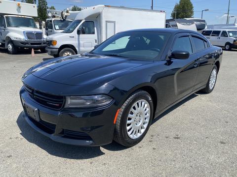 A black 2019 Dodge Charger with a sleek design and sporty front grille parked in a lot showcasing its smooth lines and modern styling