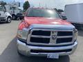 A red 2012 RAM 2500 truck with a chrome front grille and bumper is parked, showing its distinctive design and large hood