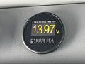 A digital voltmeter displaying a reading of 13.97 volts from Blue Sea Systems