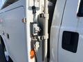 Close-up of a 2015 Ford F-450 SD with a utility bed showing various equipment mounts and a lock on the side panel