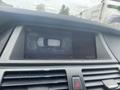 Dashboard display of a 2009 BMW X5 showing a rearview camera image of the vehicle in a parking space
