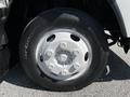 A close-up of a silver wheel rim mounted on a black tire labeled BFGoodrich with visible lug nut holes and the tire tread pattern