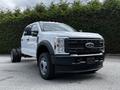A white 2024 Ford F-550 truck with a prominent front grille and dual rear wheels parked on a flat surface