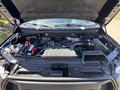 The engine compartment of a 2015 Ford F-150 with visible components like the battery coolant reservoir and engine cover