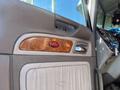 Interior door panel of a 2009 Peterbilt Highway featuring wood grain accents and a red Peterbilt logo on the armrest