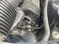 Close-up view of the engine compartment of a 2009 BMW X5 showing various components including wires and hoses
