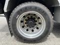 Close-up of a chrome wheel rim and tire on a 2013 Kenworth T370 showing intricate detailing on the wheel and tire tread pattern