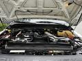 Engine compartment of a 2011 Ford F-550 with various components visible including hoses wires and a large air intake system