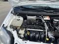 A 2010 Ford Transit Connect engine compartment displaying the engine block various hoses and fluid reservoirs