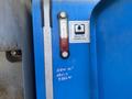 A blue 1997 Genie S-65 4X4 lift with a hydraulic fluid gauge showing red fluid level and a label indicating Dexron ATF equivalent only