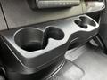 A black cup holder console in the front of a 2023 Mercedes-Benz Sprinter with two circular indentations for cups