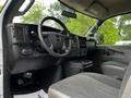 Interior view of a 2023 GMC Savana featuring a steering wheel dashboard and driver's seat with gray upholstery