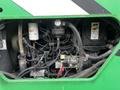 A close view of the engine compartment of a 2014 JLG 10054 with various hoses wires and components visible