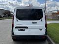 A white 2016 Ford Transit Connect van seen from the rear with tinted windows and no visible license plate