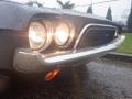A 1974 Dodge Challenger with round headlights and a prominent chrome grille showcasing a distinctive design and front bumper
