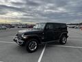 A 2019 Jeep Wrangler in black color with a rugged design parked in a lot showcasing its iconic front grille and round headlights