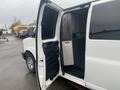 A 2012 Chevrolet Express van with an open sliding door revealing the interior space and a partition divider