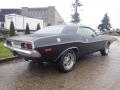 A 1974 Dodge Challenger in black with a sleek design chrome details and radial tires showcasing a classic muscle car aesthetic