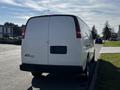 A white 2015 Chevrolet Express van parked on the street with a plain rear view and no visible markings or graphics