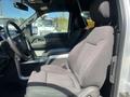 Interior view of a 2014 Ford F-150 showing a driver's seat and center console with a cup holder and gear shifter