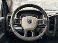 Steering wheel of a 2012 Dodge Ram 5500 with the emblem in the center and control buttons on the left side
