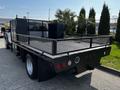 A 2016 Ford F-550 flatbed truck with a black metal frame and mesh sides parked with utility features visible