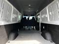 Interior view of a 2019 Mercedes-Benz Sprinter showing the cargo area with gray walls and flooring two rows of black seats visible at the back