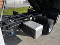 A 2021 Ford F-550 chassis with an open hood displaying the engine compartment and a large metal storage box on the side of the frame
