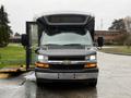 A 2019 Chevrolet Express with an open side door features a black and silver exterior and front headlights visible