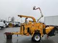 A yellow 1993 Bandit 200+ wood chipper with a large feeding chute and attached hydraulic lift arm for elevating debris